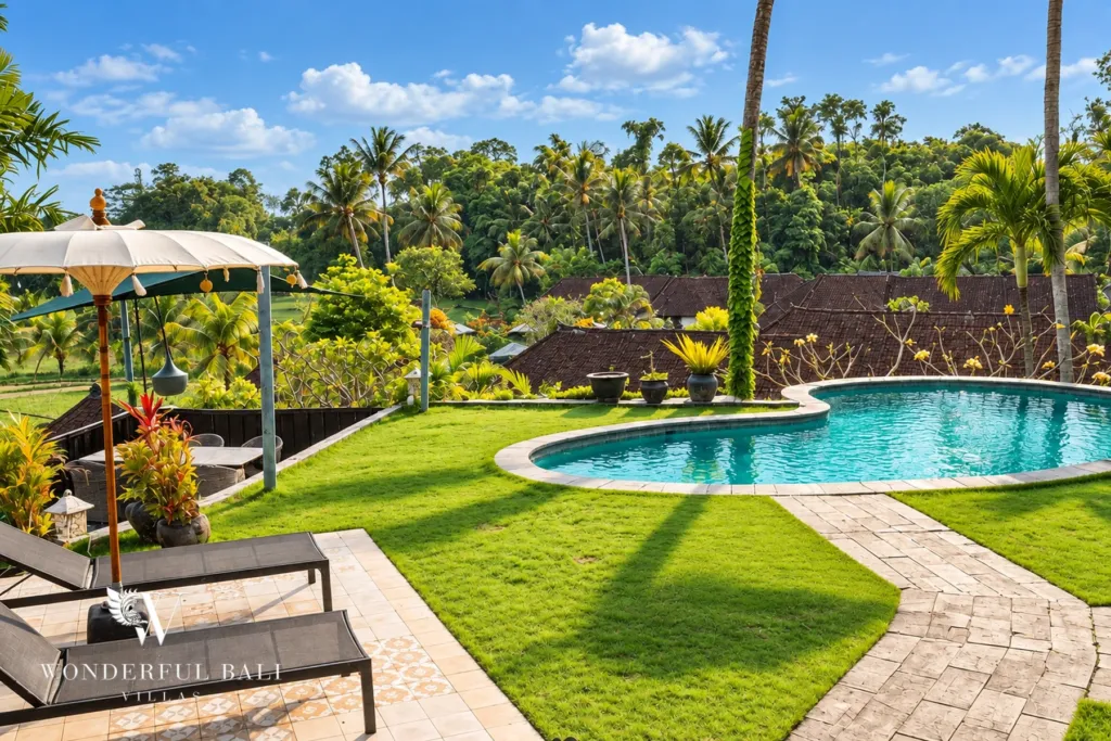3BR villa for rent in Tabanan — pool, lawn and sun loungers with rice fields and palms beyond