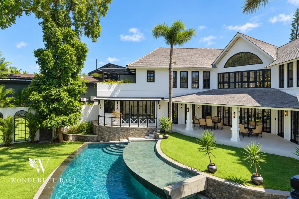 7BR villa for sale in Umalas — curved pool and lawn below the two-storey colonial villa