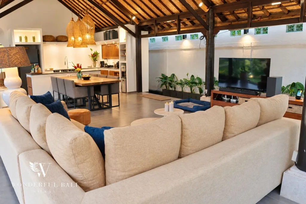 3BR villa for rent in Tabanan — sectional sofa and TV in the open living room, kitchen behind