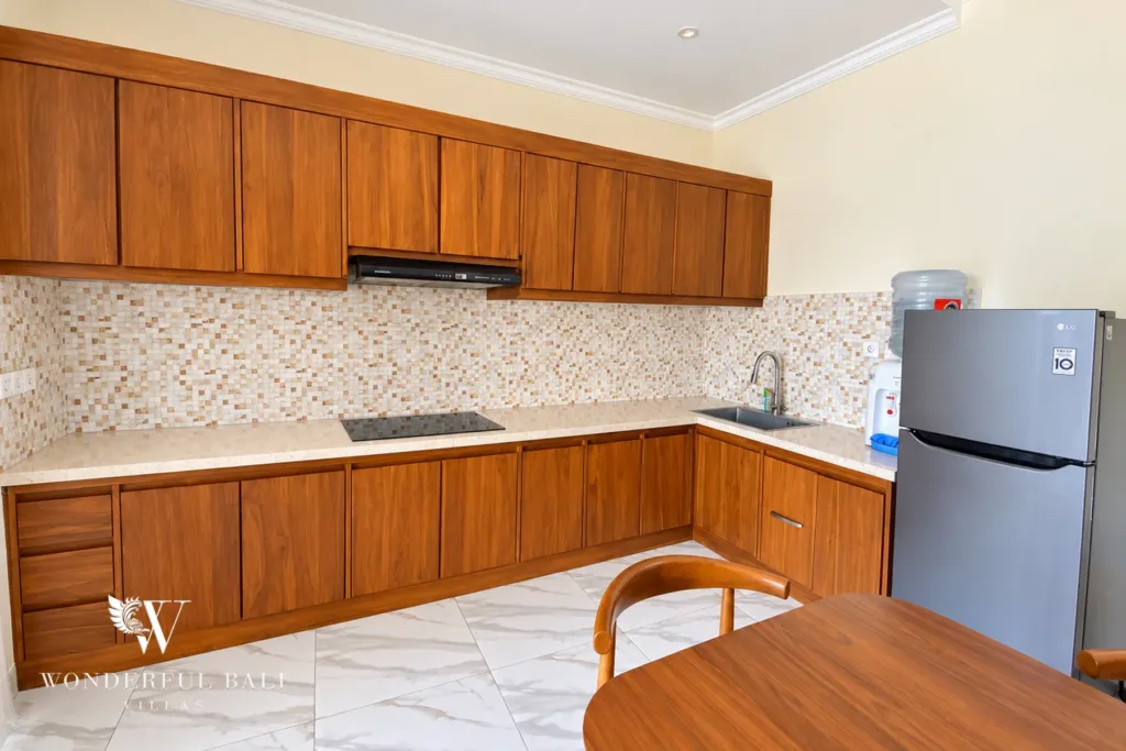 3BR villa for sale or rent in Sanur — wooden kitchen with hob, fridge and dining chair