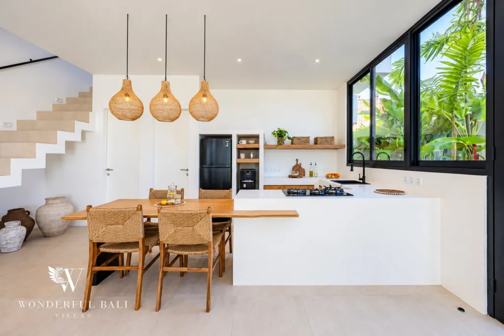 2BR villa for rent in Munggu — white kitchen island with a timber dining table