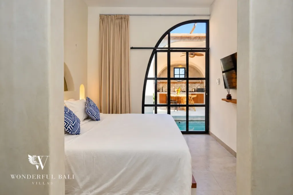 2BR villa for sale in Sanur — bedroom with arched glass door to the pool courtyard