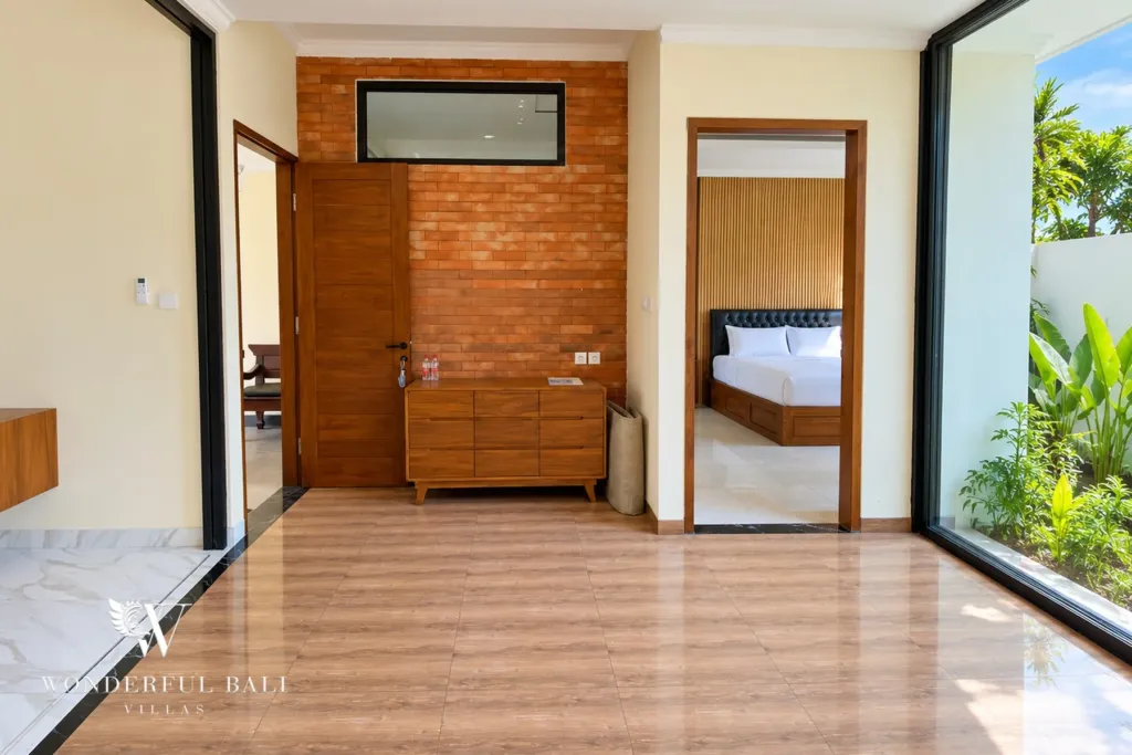3BR villa for sale or rent in Sanur — living hall with brick feature wall and timber floor