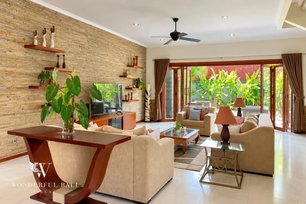 3BR villa for rent in Sanur — living room with stone feature wall and garden doors