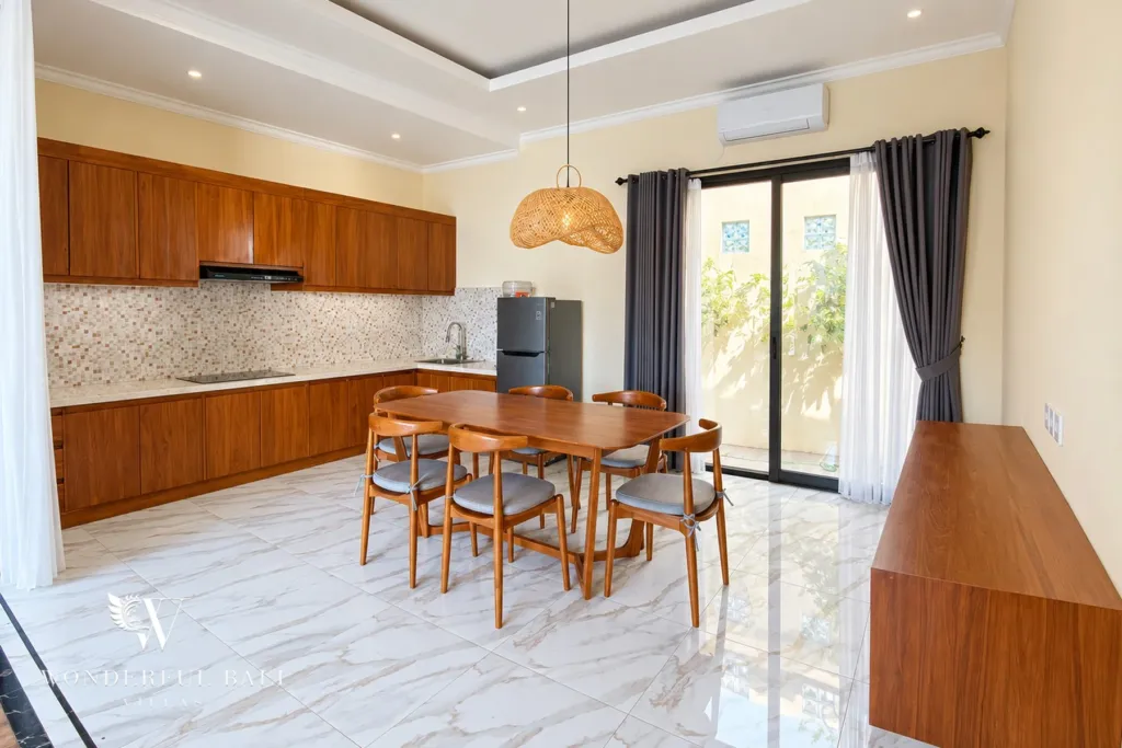 3BR villa for sale or rent in Sanur — dining table for six beside the wooden kitchen