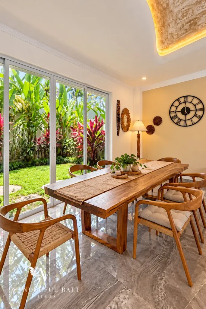 3BR villa for rent in Padonan — teak dining table beside glass doors to the garden