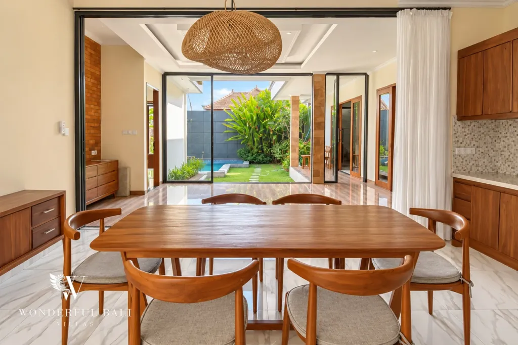 3BR villa for sale or rent in Sanur — wooden dining table under a rattan pendant with garden view