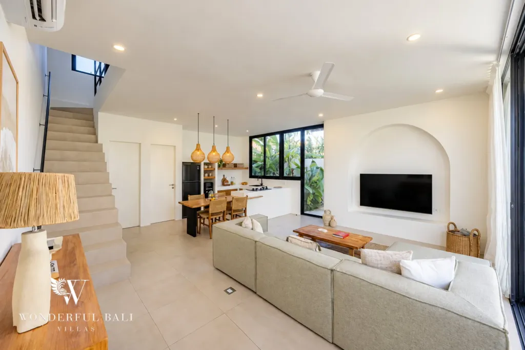 2BR villa for rent in Munggu — living area with the kitchen and staircase beyond