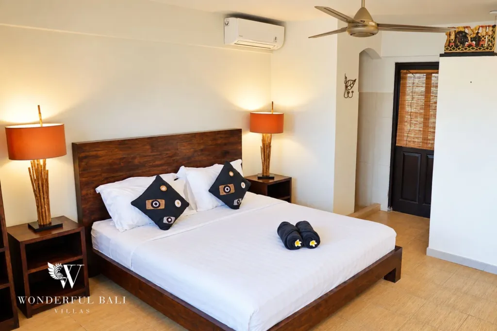 3BR villa for rent in Tabanan — bedroom with timber bed, air conditioning and ceiling fan