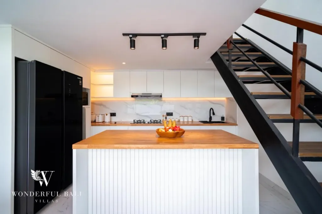 3BR villa for sale in Saba, Gianyar — white kitchen with timber-top island and black fridge