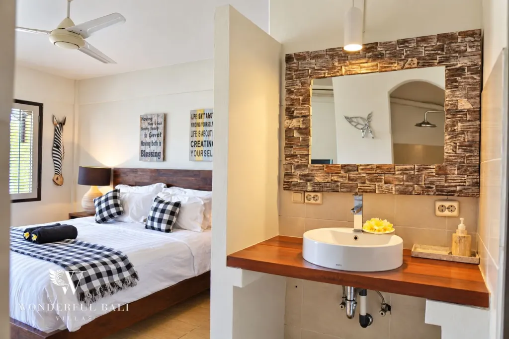 3BR villa for rent in Tabanan — bedroom with stone-framed mirror and vanity