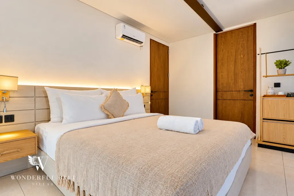 4BR villa for sale in Canggu — bedroom with lit headboard and timber door
