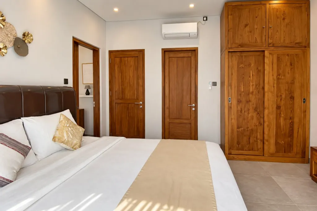 3BR villa for rent in Sanur — main bedroom with en-suite door and teak wardrobe