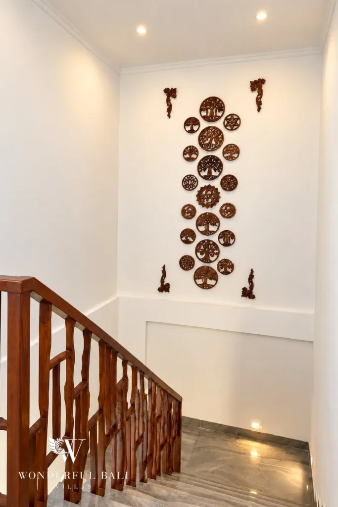 3BR villa for rent in Padonan — stair landing with carved timber wall art