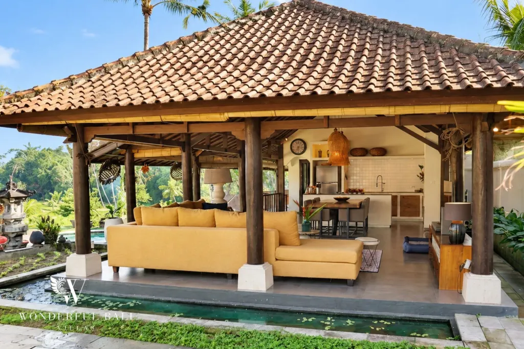 3BR villa for rent in Tabanan — open living pavilion with yellow sofa beside a pond