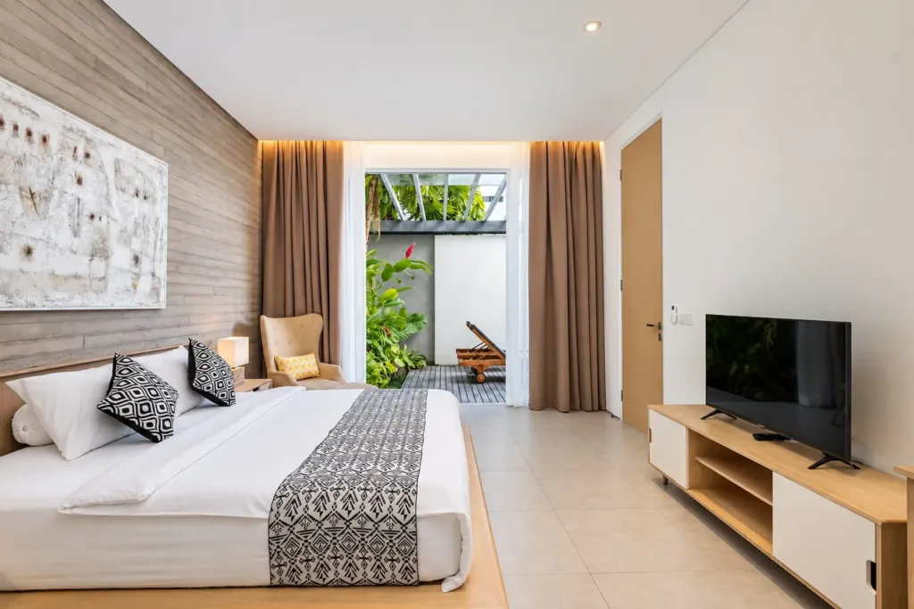 Villa Swan 02 — bedroom 2, king bed, smart TV on a timber console and curtained doors to the terrace