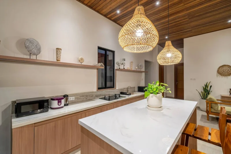 Villa LaBumbak, Umalas — kitchen, white stone island and counter with hob, window onto tropical planting