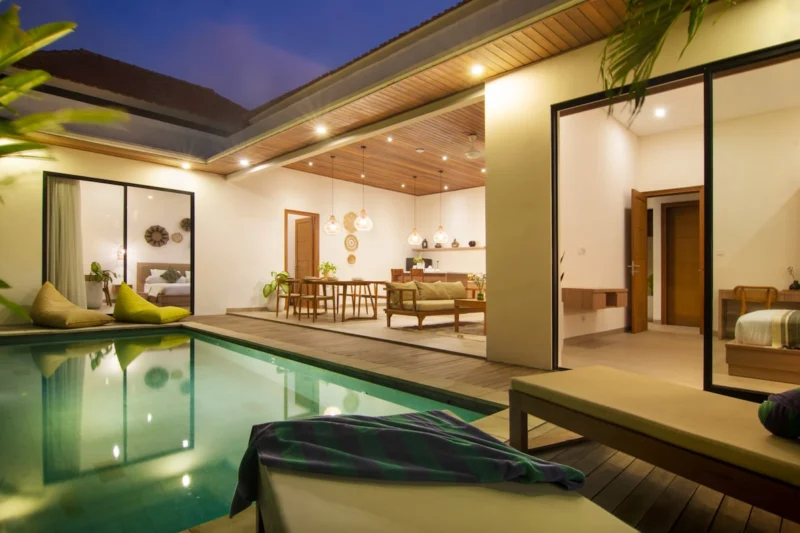 Villa LaBumbak, Umalas — pool, pool at blue hour with the living and dining room lit behind glass