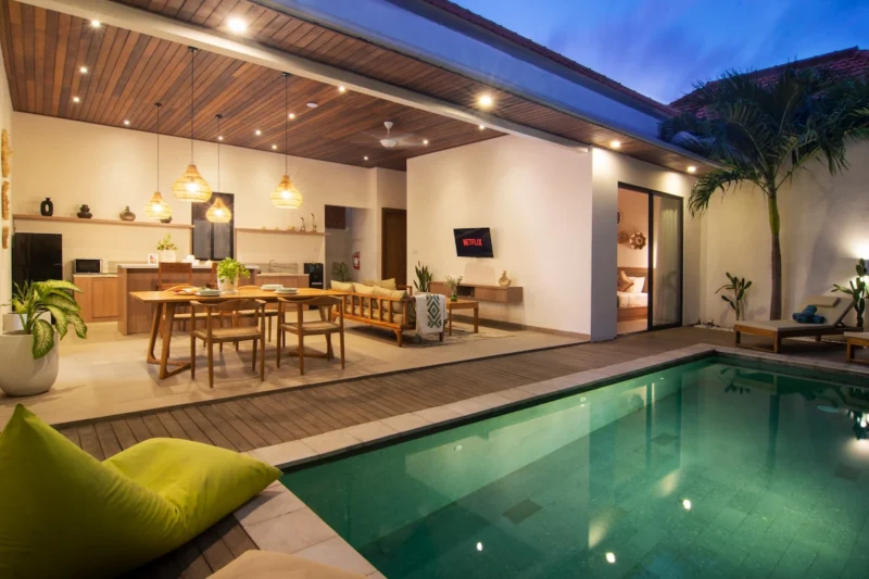 Villa LaBumbak, Umalas — pool, pool at dusk with the lit open-plan living, dining and kitchen behind, palms alongside