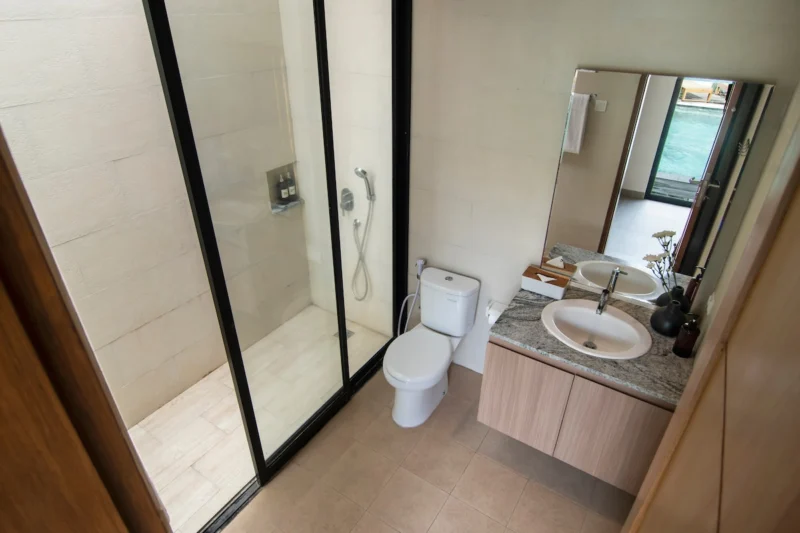 Villa LaBumbak, Umalas — bathroom 2, shower and marble-topped vanity, mirror reflecting the doorway onto the pool terrace