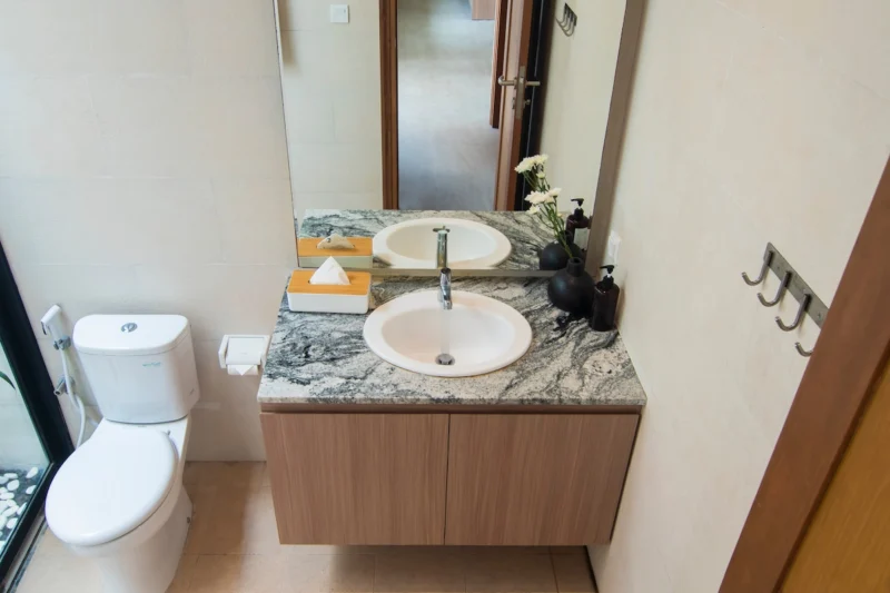 Villa LaBumbak, Umalas — bathroom 2, marble-topped vanity with mirror and towel hooks, timber door alongside