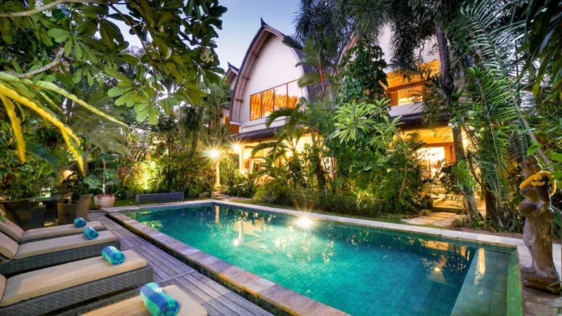 View of the pool and garden at sunset in Villa Bali Maja.