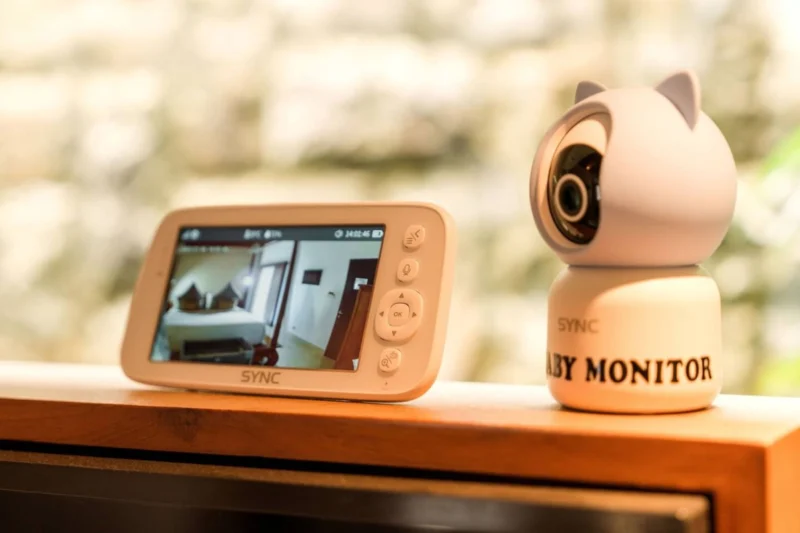 Baby monitor amenity in Seminyak, Bali — SYNC video baby monitor screen and camera unit on teak shelf, available on request for families with infants.