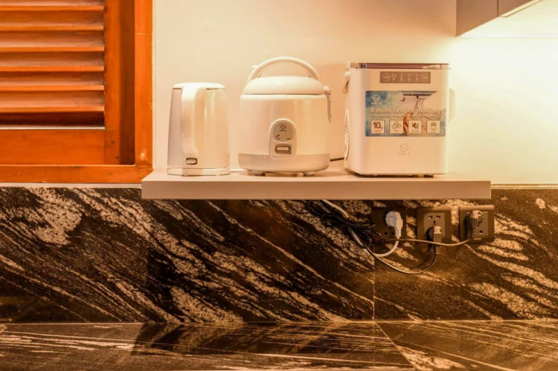 The kitchen is equipped for guests who actually cook: Nespresso-style coffee machine, rice cooker, convection oven with air fryer, microwave, full hob, and real bench space to use it all. Not a holiday rental afterthought — a proper home kitchen setup.