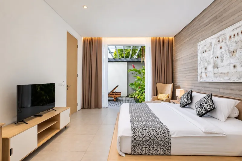 Villa Swan 01 — bedroom 2, king bed, smart TV on a timber console and curtained doors to the terrace