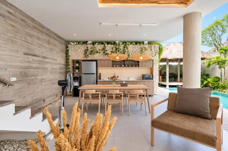 Villa Swan 01 — dining, table and kitchen against a stacked stone wall with dried pampas
