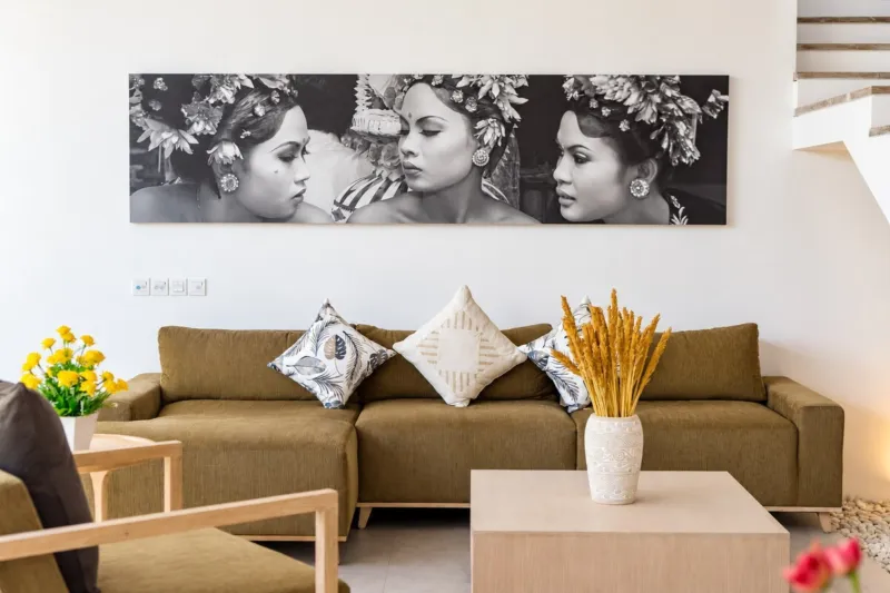 Villa Swan 01 — living, brown sofa with woven cushions below a canvas of Balinese dancers